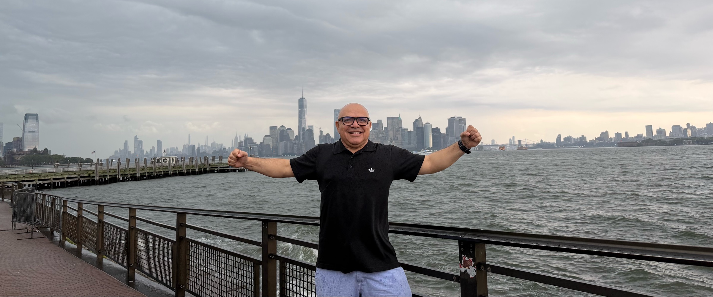 Viajante comemorando no píer com a skyline de Manhattan ao fundo